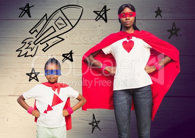 Portrait of mother and daughter wearing red cape and mask against wooden background