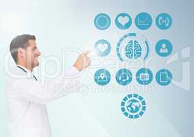 Doctor touching digitally generated medical icons against white background