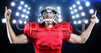American football player celebrating against floodlights in background