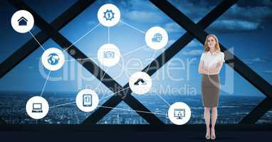 Businesswoman standing with various application icon against cityscape background