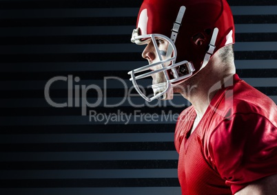 American football player standing against striped black background