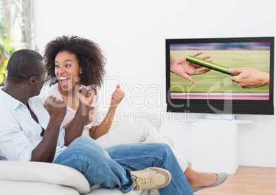 Excited couple cheering and watching a sports in television