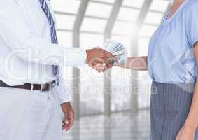 Businessman bribing partner while shaking hands