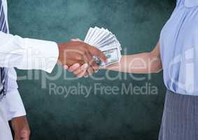 Businessman bribing partner while shaking handsÃ?Â against teal background