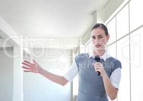 Businesswoman public speaking on microphone in office