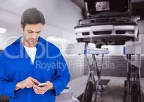 Mechanic using mobile phone at garage