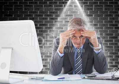 Stressed businessman sitting at computer desk