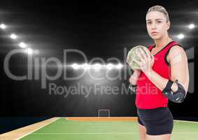 Female handball player holding ball at handball court