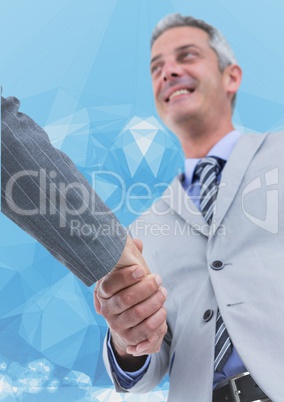 Business executives shaking hands against blue background