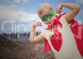 Girl in superhero costume flexing her arms against cityscape