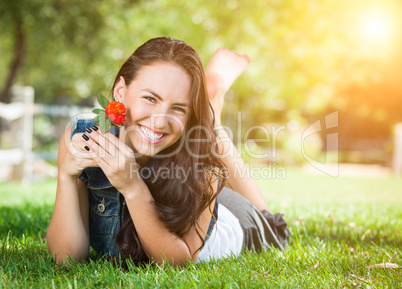 Attractive Mixed Race Girl Holding Flower Portrait Laying in Gra