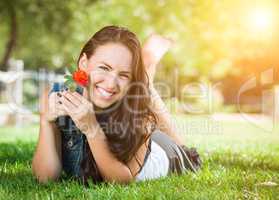 Attractive Mixed Race Girl Holding Flower Portrait Laying in Gra