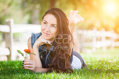 Attractive Mixed Race Girl Holding Flower Portrait Laying in Gra