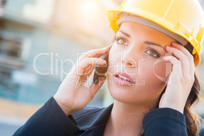 Worried Female Contractor Wearing Hard Hat on Site Using Cell Ph