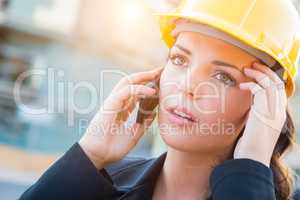 Worried Female Contractor Wearing Hard Hat on Site Using Cell Ph