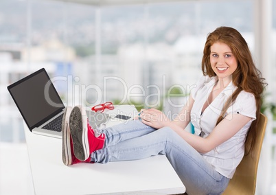 Woman sitting with feet resting on table