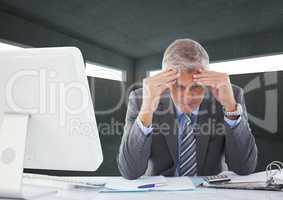 Tensed businessman sitting at desk