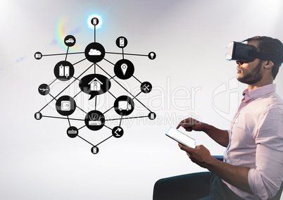 Man using digital tablet while wearing virtual reality headset with cloud connectivity interface