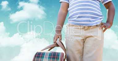 Man carrying a bag against sky in background