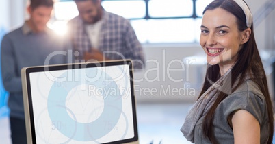 Woman smiling while using desktop pc at office
