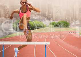 Digital composite image of female athlete jumping above the hurdle