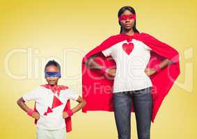 Daughter and mother wearing superhero costume standing with hands on hips