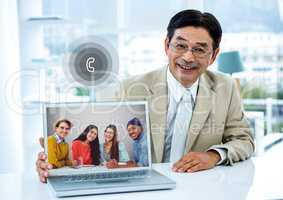 Portrait of businessman having video call with colleagues on laptop in office