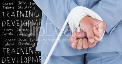 Digital composite image of a businessman with hands tied and training and development concept