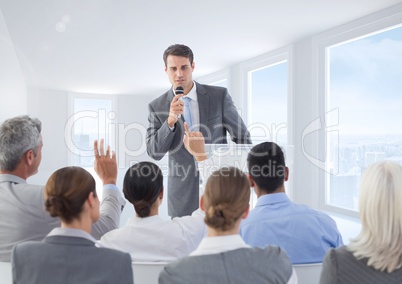 Businessman speaking on microphone in meeting