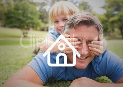 Dad and son lying on the garden against home outline n background