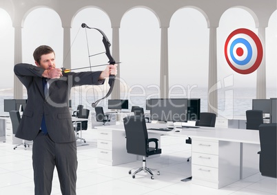 Businessman aiming at the target board against office in background