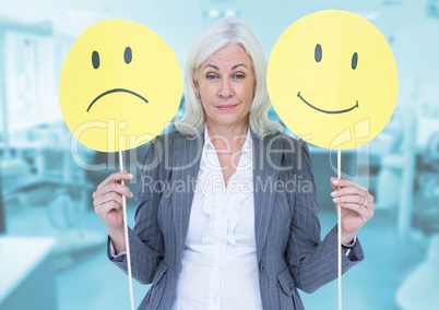 Portrait of a businesswoman holding smiley and sad faces