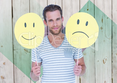 Man holding happy and sad smiley faces