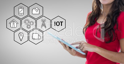 Mid section of woman using digital tablet and various icons in background