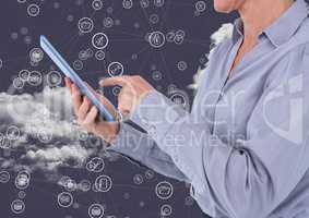 Businesswoman using digital tablet against technology icons in sky