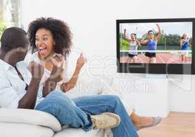 Excited couple cheering and watching a sports in television