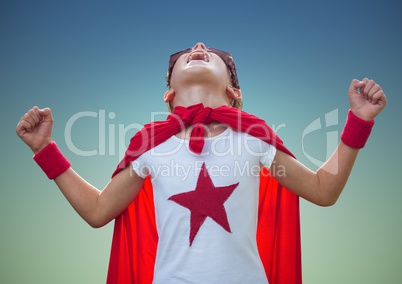 Boy pretending to be a superhero against blue background