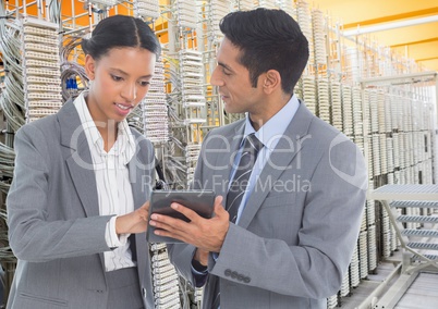 Business colleagues using digital tablet against database server systems in background