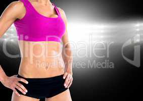 Fitness woman standing with hands on her hip against black background