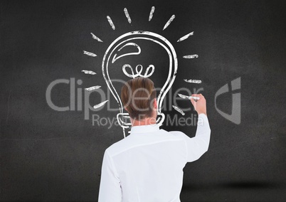 Man drawing a light bulb on blackboard