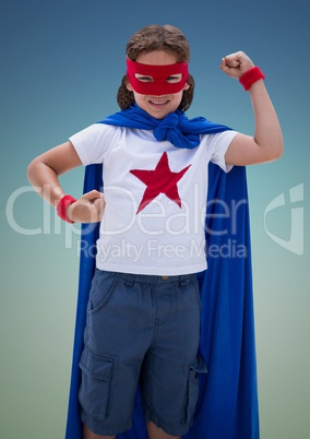 Boy pretending to be a superhero against blue background