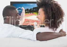 Couple smiling while watching swimming on television