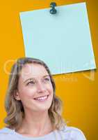 Woman looking at blank sticky note