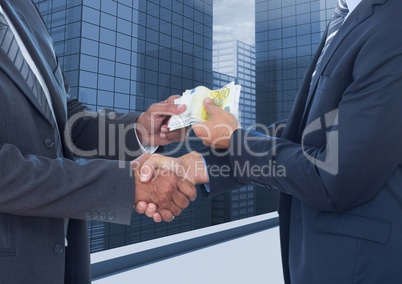 Businessmen shaking hands and receiving banknotes