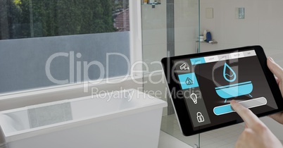 Hand holding digital tablet with home security icons on screen