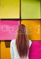 Rear view of woman looking at large multicolored sticky note