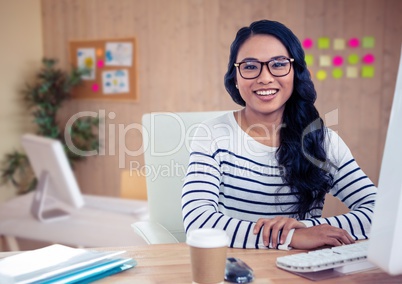 Woman in spectacles sitting on her desk at office