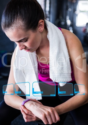 Woman looking at fitness band on wrist in gym