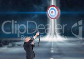 Businessman holding a cross bow and aiming at the target board