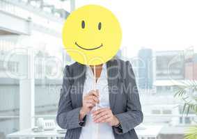 Businesswoman covering her face with happy smiley face